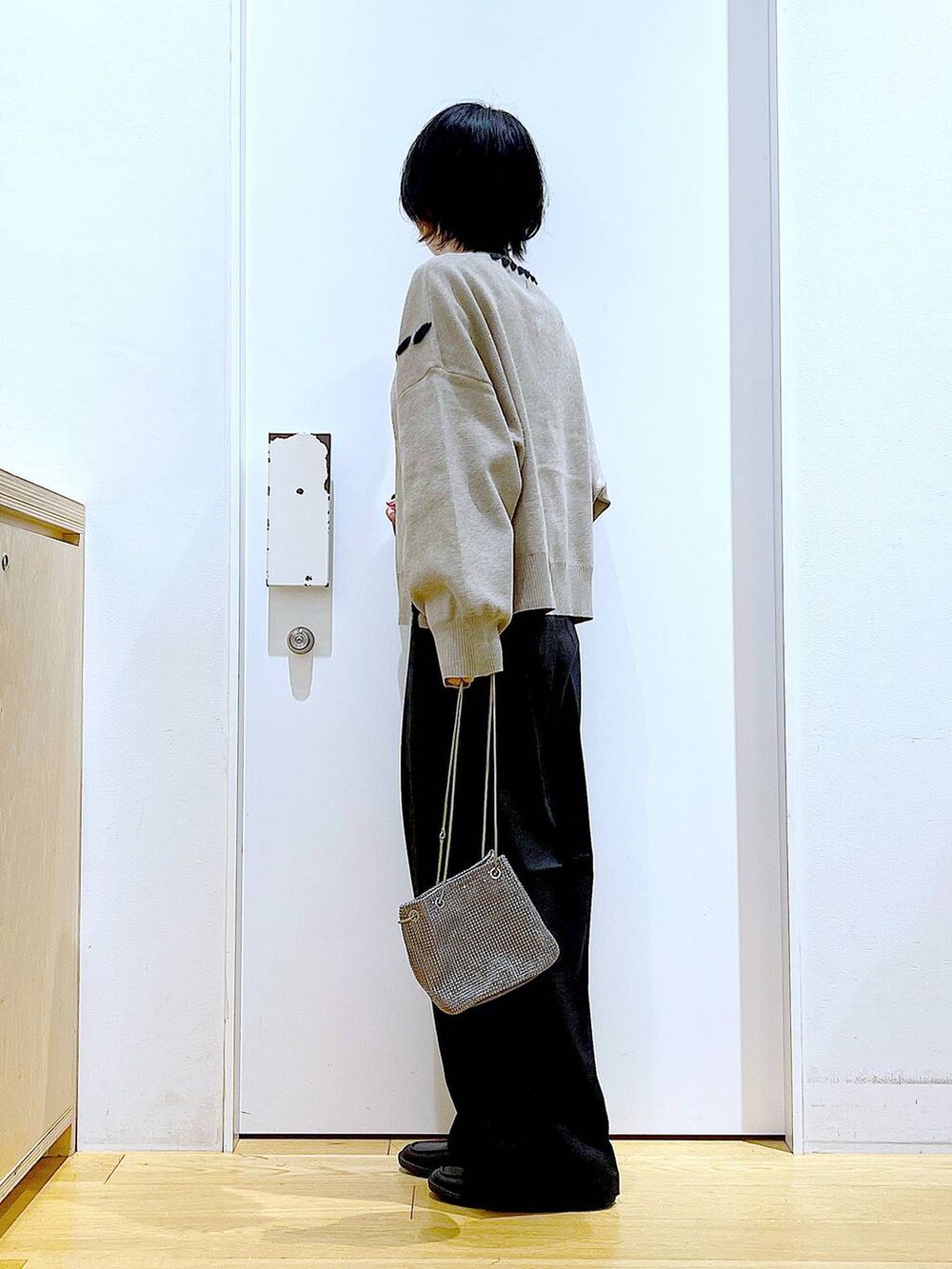 グレー系のショルダーバッグ、ブラック系のローファー、ブラウン系のニット/セーターを着用したレディースの冬コーディネートの3枚目の写真