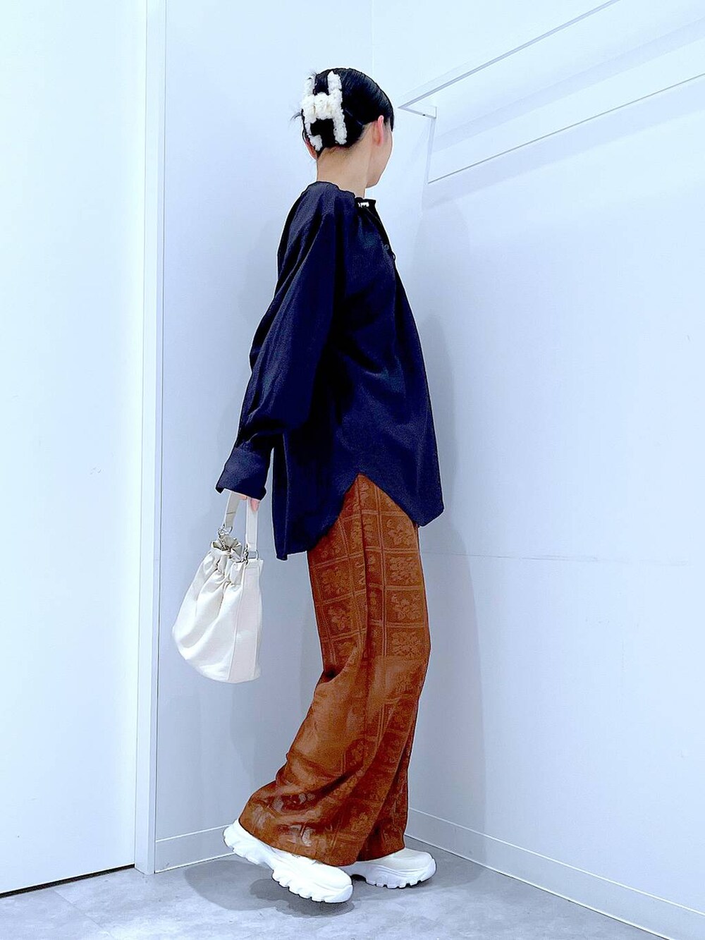 ブラック系のシャツ/ブラウス、ホワイト系のショルダーバッグ、ホワイト系のスニーカーを着用したレディースの春コーディネートの4枚目の写真