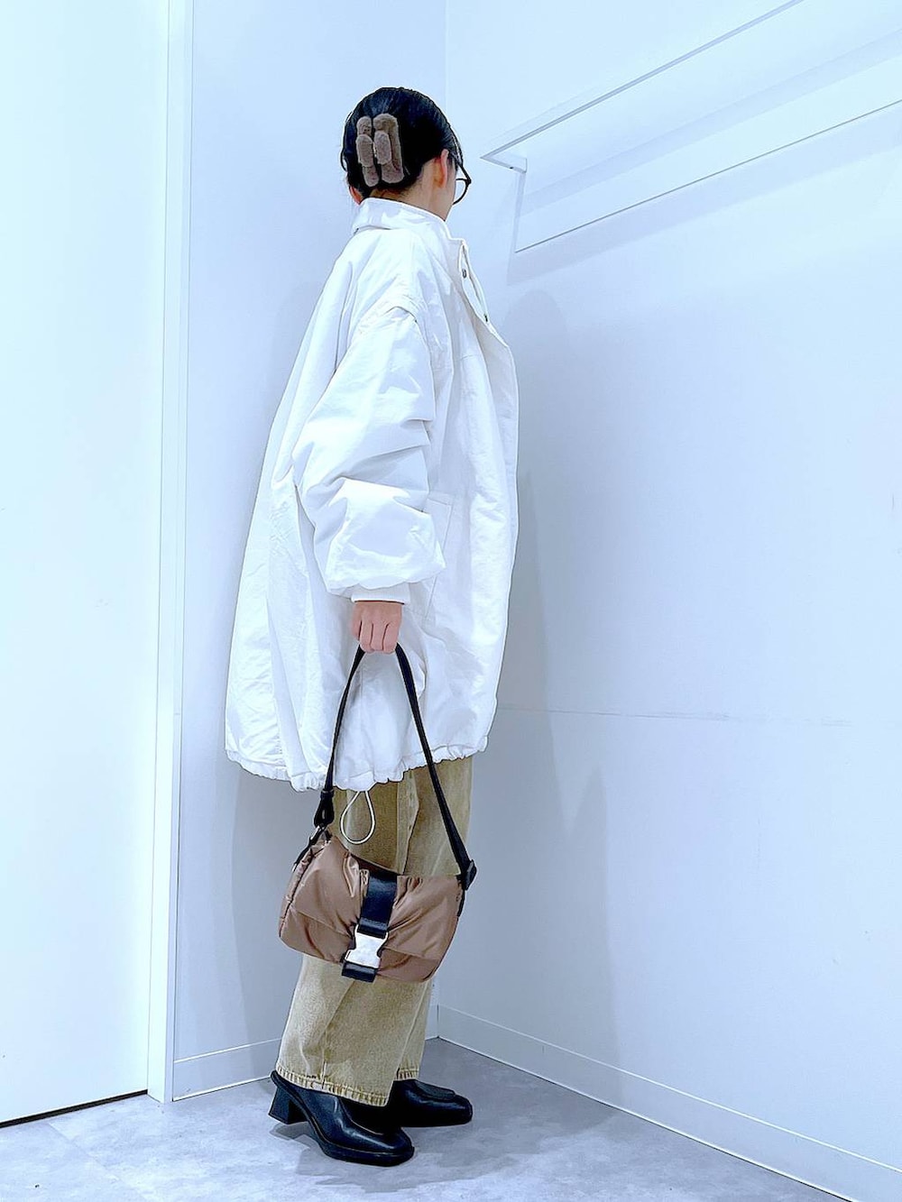 ベージュ系のデニムパンツ、ホワイト系のブルゾン、ブラック系のブーツを着用したレディースの冬コーディネートの4枚目の写真