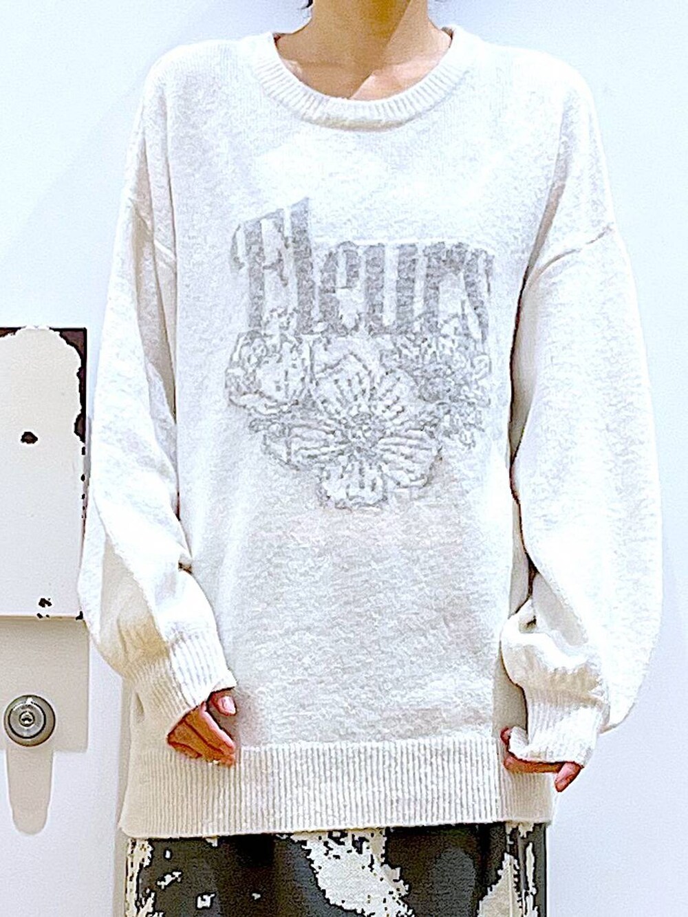 グレー系のスカート、ブラック系のブーツ、ベージュ系のニット/セーターを着用したレディースの秋コーディネートの7枚目の写真