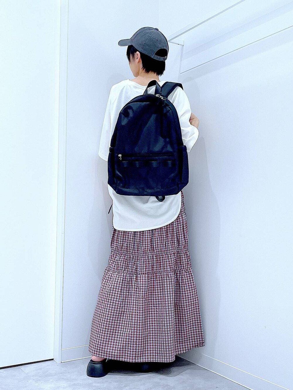 ブラック系のバックパック/リュック、シルバー系のサンダル、ホワイト系のTシャツ/カットソーを着用したレディースの夏コーディネートの5枚目の写真