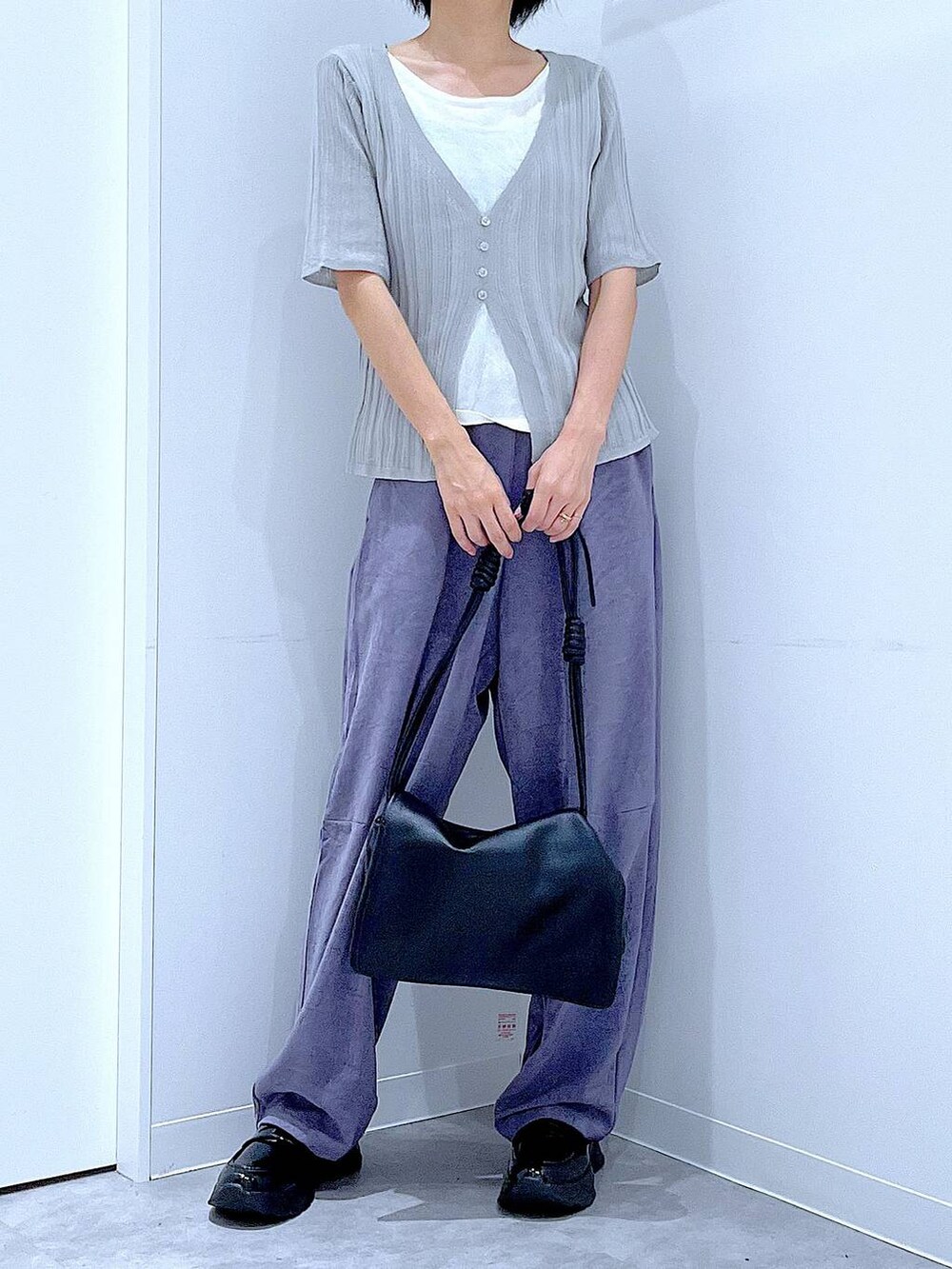 ブラック系のショルダーバッグ、ブラック系のローファー、グレー系のニット/セーターを着用したレディースの秋コーディネートの6枚目の写真