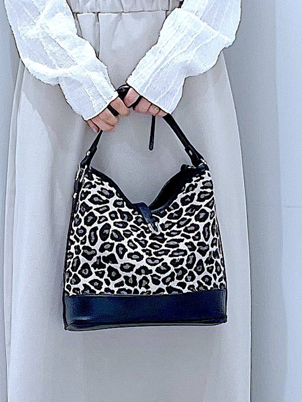 ベージュ系のスカート、ホワイト系のローファー、その他のショルダーバッグを着用したレディースの秋コーディネートの9枚目の写真