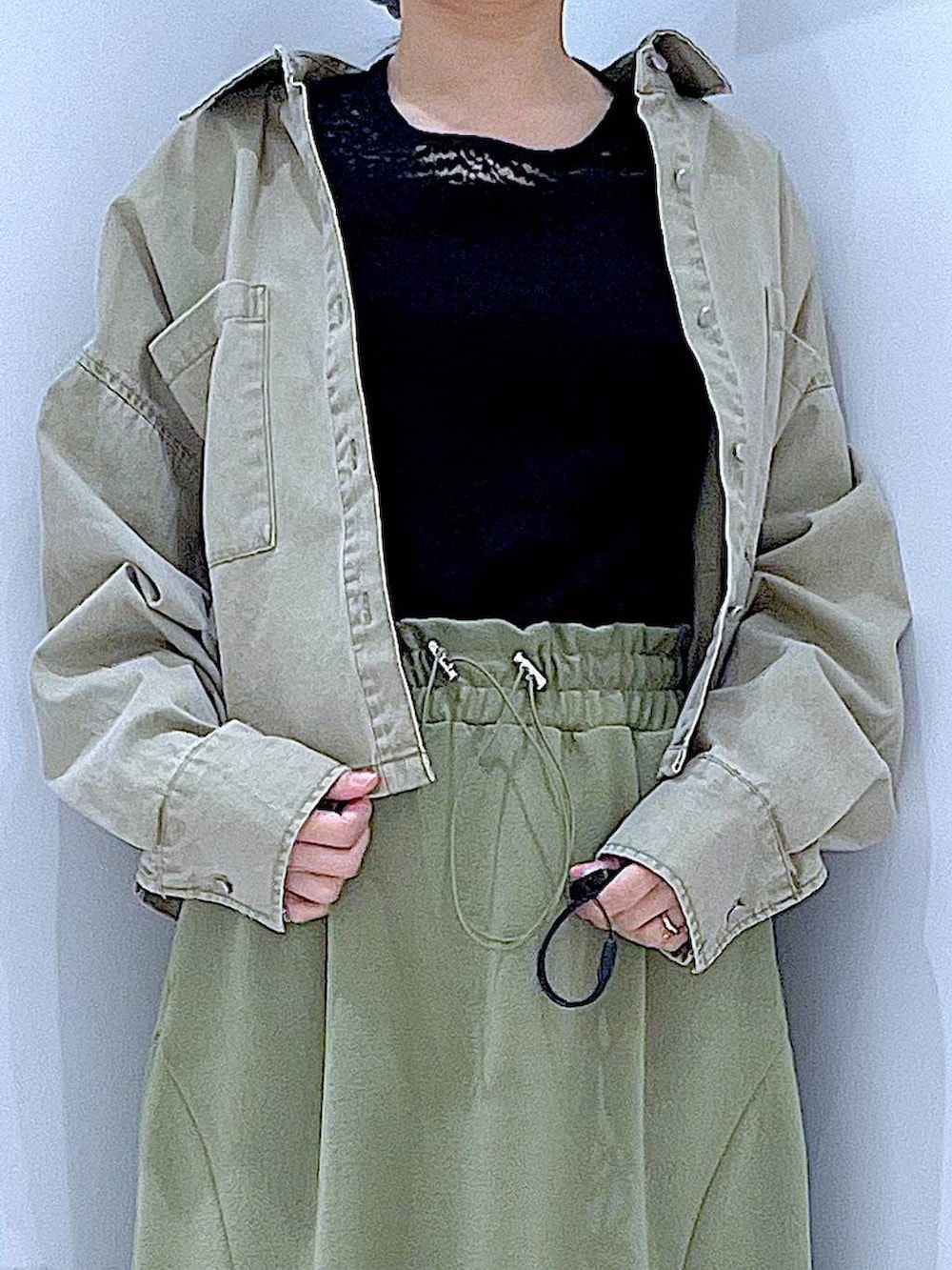 ブラック系のTシャツ/カットソー、ブラック系のショルダーバッグ、ベージュ系のシャツ/ブラウスを着用したレディースの冬コーディネートの7枚目の写真