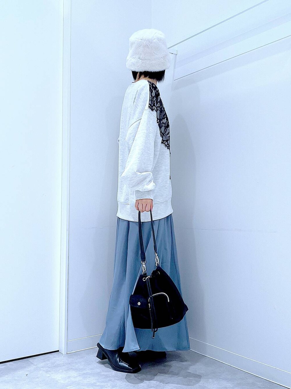 ブラック系のショルダーバッグ、ブラック系のブーツ、ベージュ系のスウェットを着用したレディースの冬コーディネートの4枚目の写真