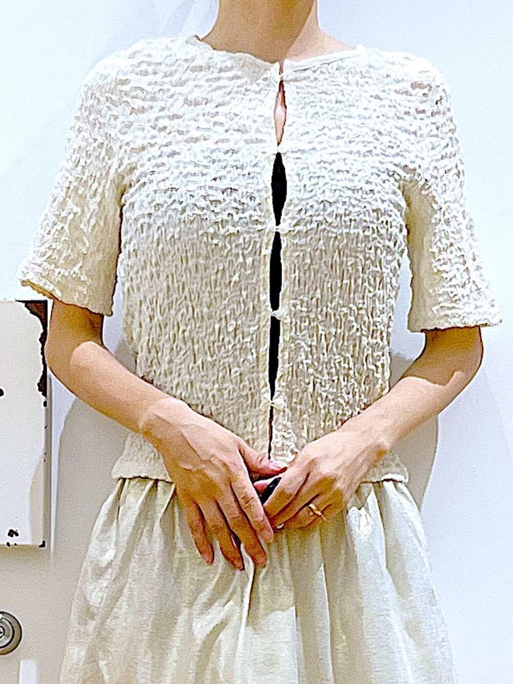 ホワイト系のサンダル、グレー系のトートバッグ、ゴールド系のスカートを着用したレディースの夏コーディネートの7枚目の写真