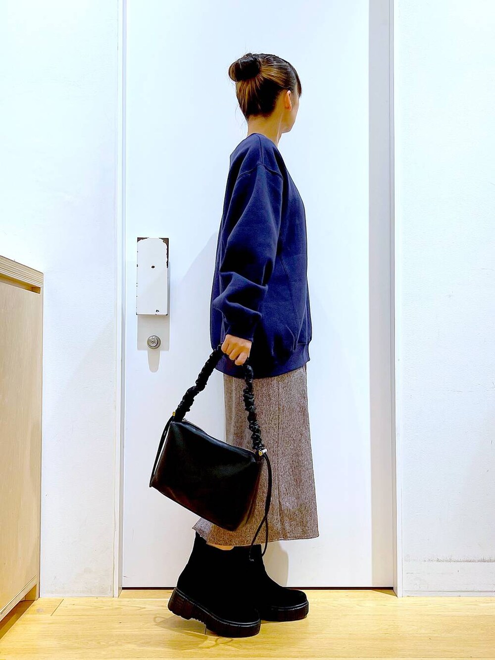 ブラック系のショルダーバッグ、ブラック系のブーツ、ブラウン系のワンピースを着用したレディースの冬コーディネートの4枚目の写真