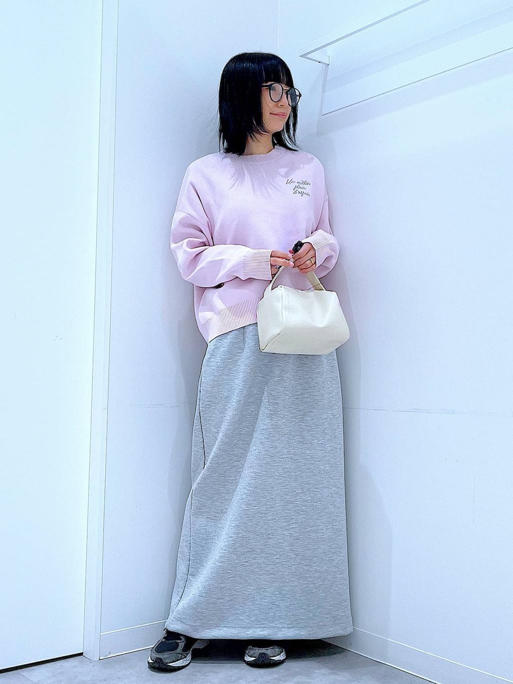 ホワイト系のショルダーバッグ、ピンク系のニット/セーター、グレー系のスカートを着用したレディースの冬コーディネートの2枚目の写真