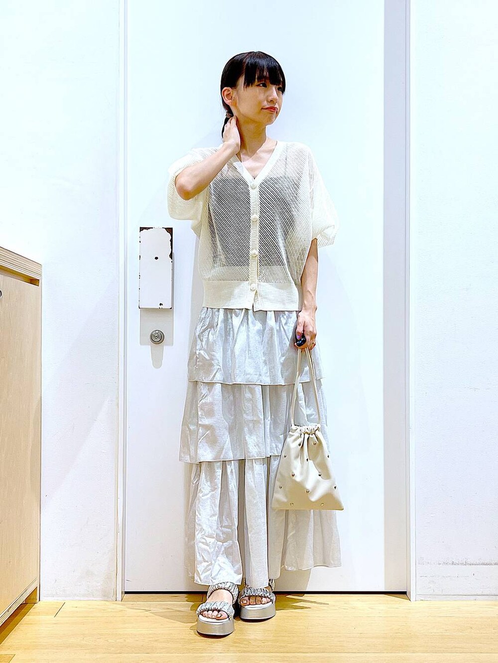 シルバー系のサンダル、ホワイト系のショルダーバッグ、シルバー系のスカートを着用したレディースの夏コーディネートの2枚目の写真