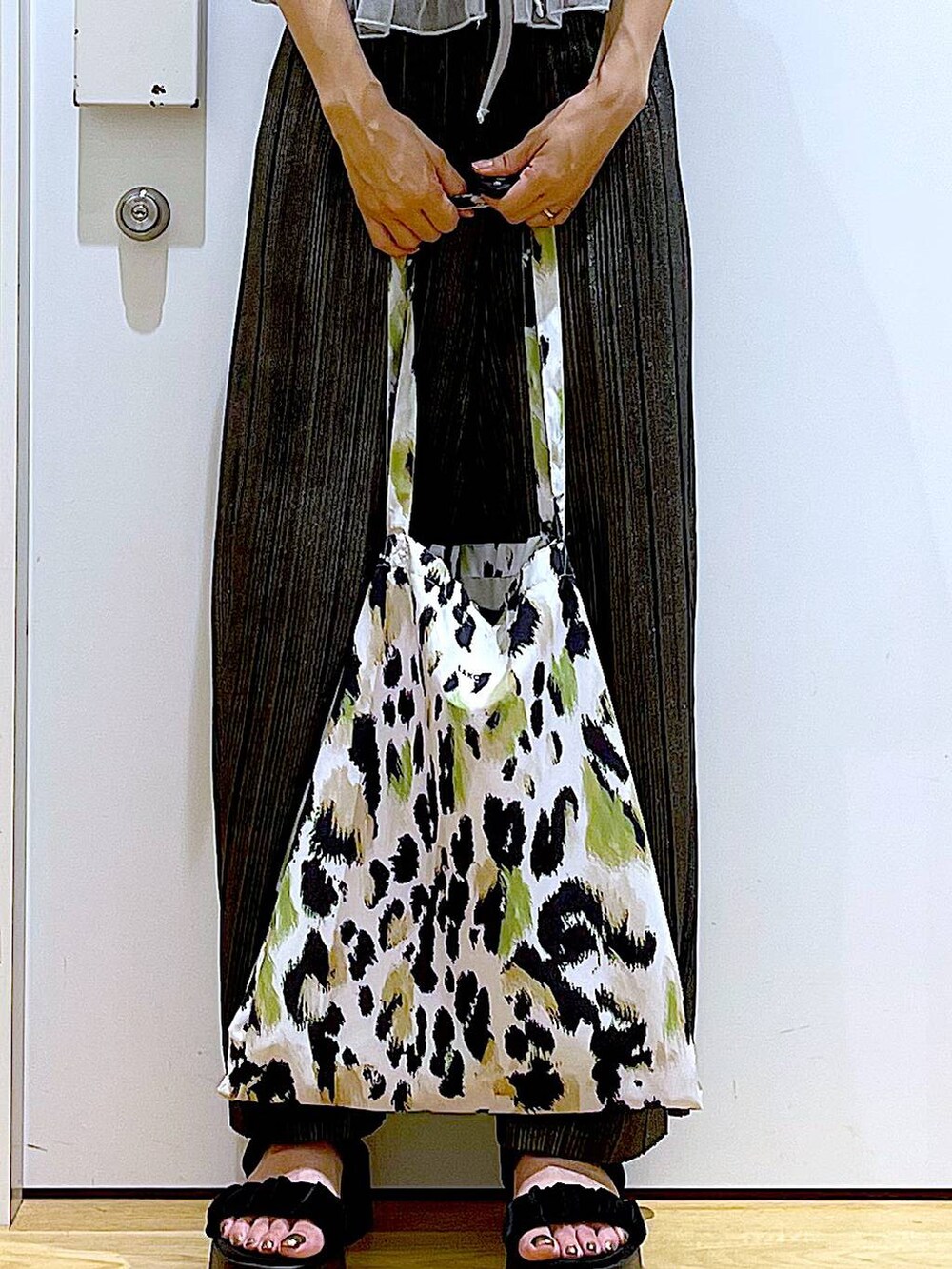 グリーン系のトートバッグ、シルバー系のキャミソール、ホワイト系のTシャツ/カットソーを着用したレディースの夏コーディネートの9枚目の写真