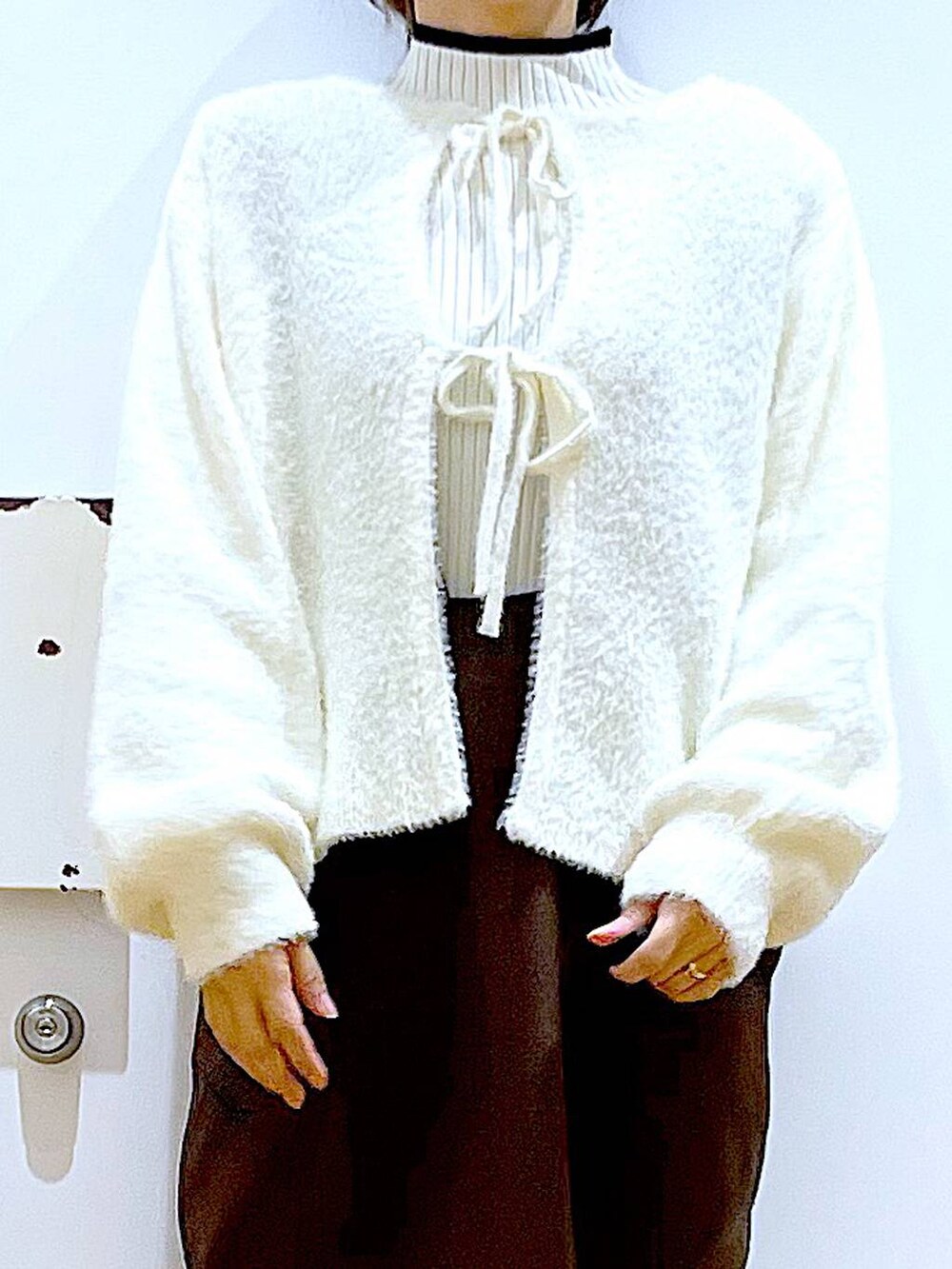 ベージュ系のニット/セーター、ベージュ系のブーツ、ブラウン系のサロペット/オーバーオールを着用したレディースの冬コーディネートの7枚目の写真