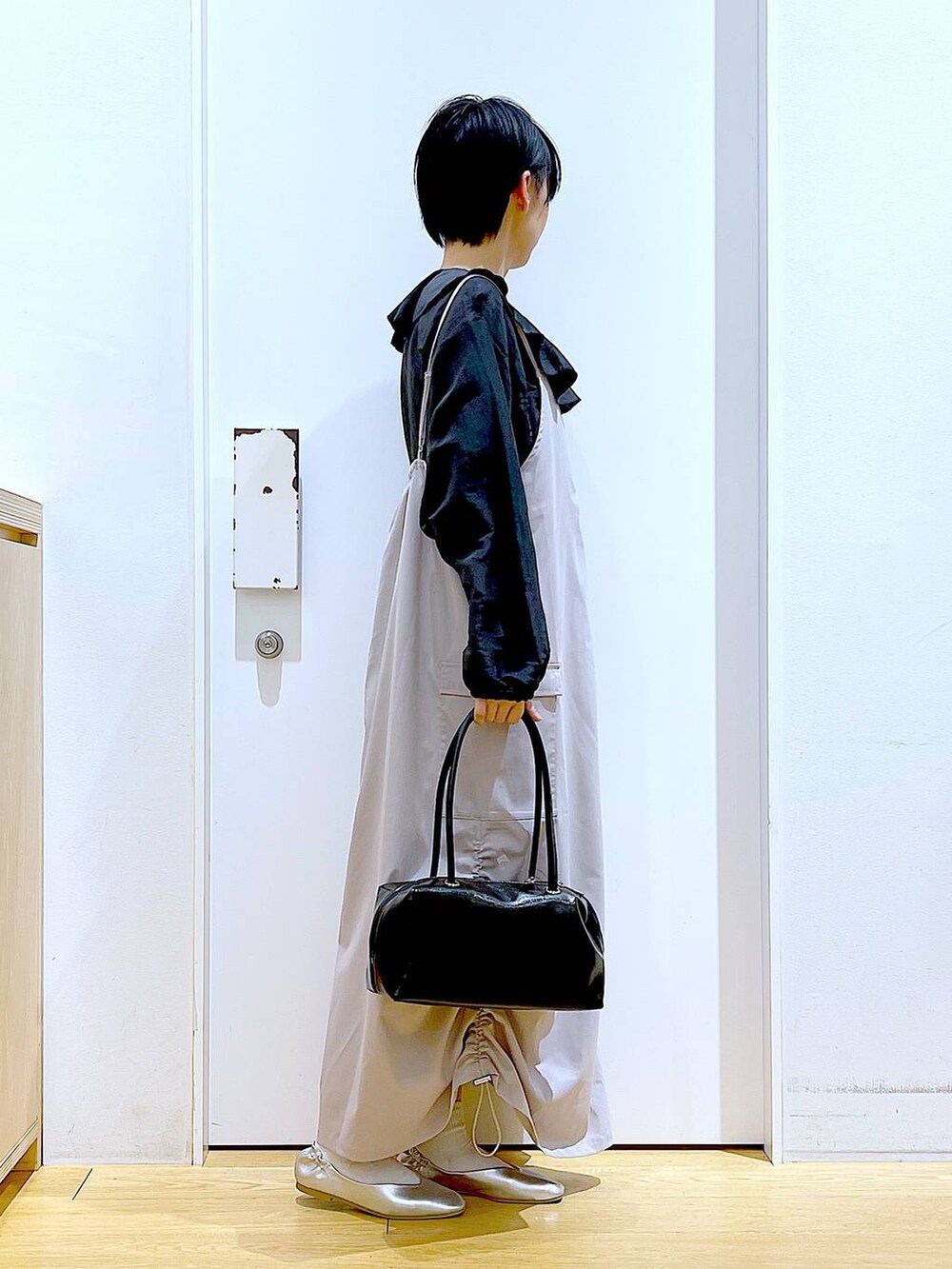 ブラック系のボストンバッグ、シルバー系のパンプス、グレー系のシャツ/ブラウスを着用したレディースの春コーディネートの4枚目の写真