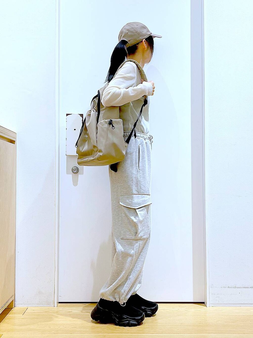 グレー系のスウェットパンツ、ベージュ系のバックパック/リュック、ブラック系のスニーカーを着用したレディースの春コーディネートの4枚目の写真