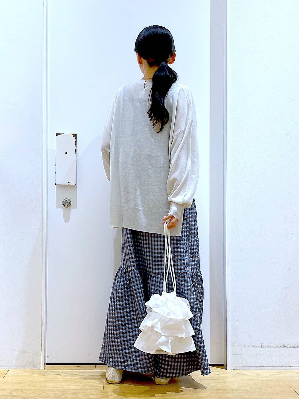 ホワイト系のショルダーバッグ、ブルー系のワンピース、ホワイト系のパンプスを着用したレディースの春コーディネートの5枚目の写真