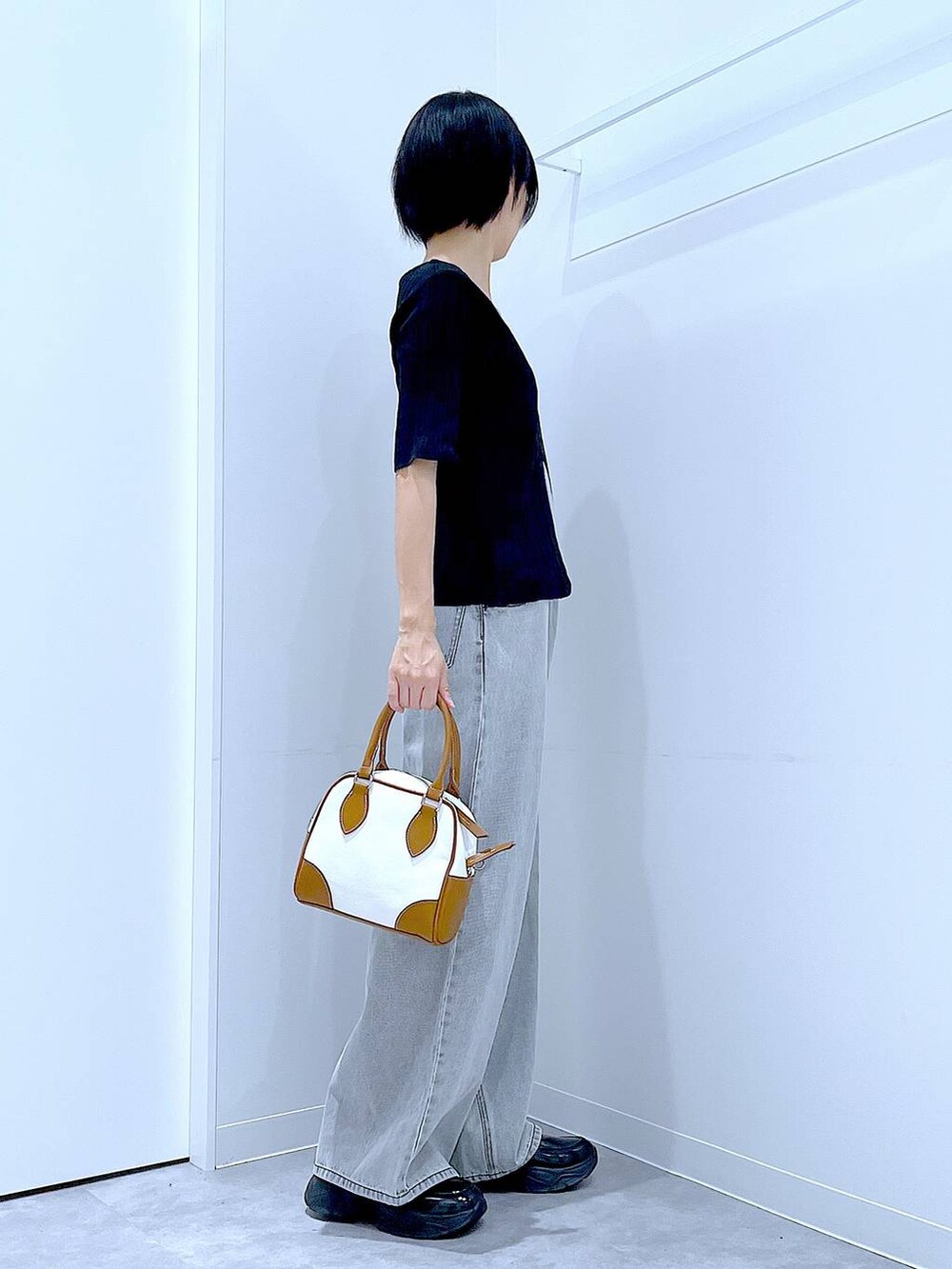 ブラック系のローファー、ホワイト系のハンドバッグ、ブラック系のニット/セーターを着用したレディースの秋コーディネートの4枚目の写真