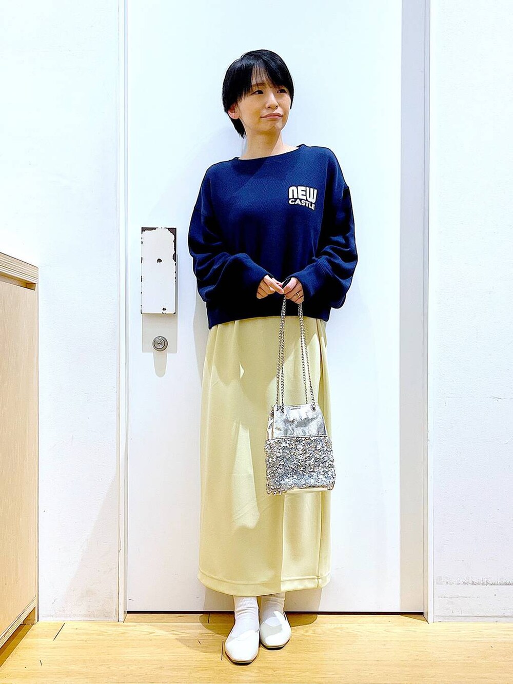 ホワイト系のパンプス、ブルー系のTシャツ/カットソー、イエロー系のスカートを着用したレディースの春コーディネートの2枚目の写真