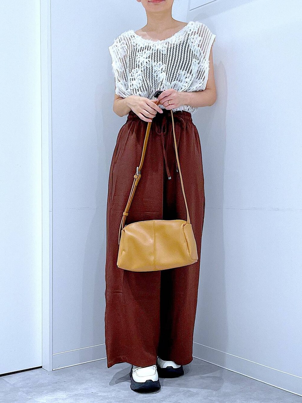 ベージュ系のショルダーバッグ、ホワイト系のローファー、ブラウン系のその他パンツを着用したレディースの秋コーディネートの6枚目の写真