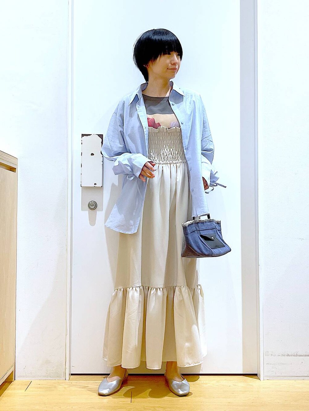 シルバー系のパンプス、ブルー系のショルダーバッグ、ブルー系のシャツ/ブラウスを着用したレディースの春コーディネートの2枚目の写真