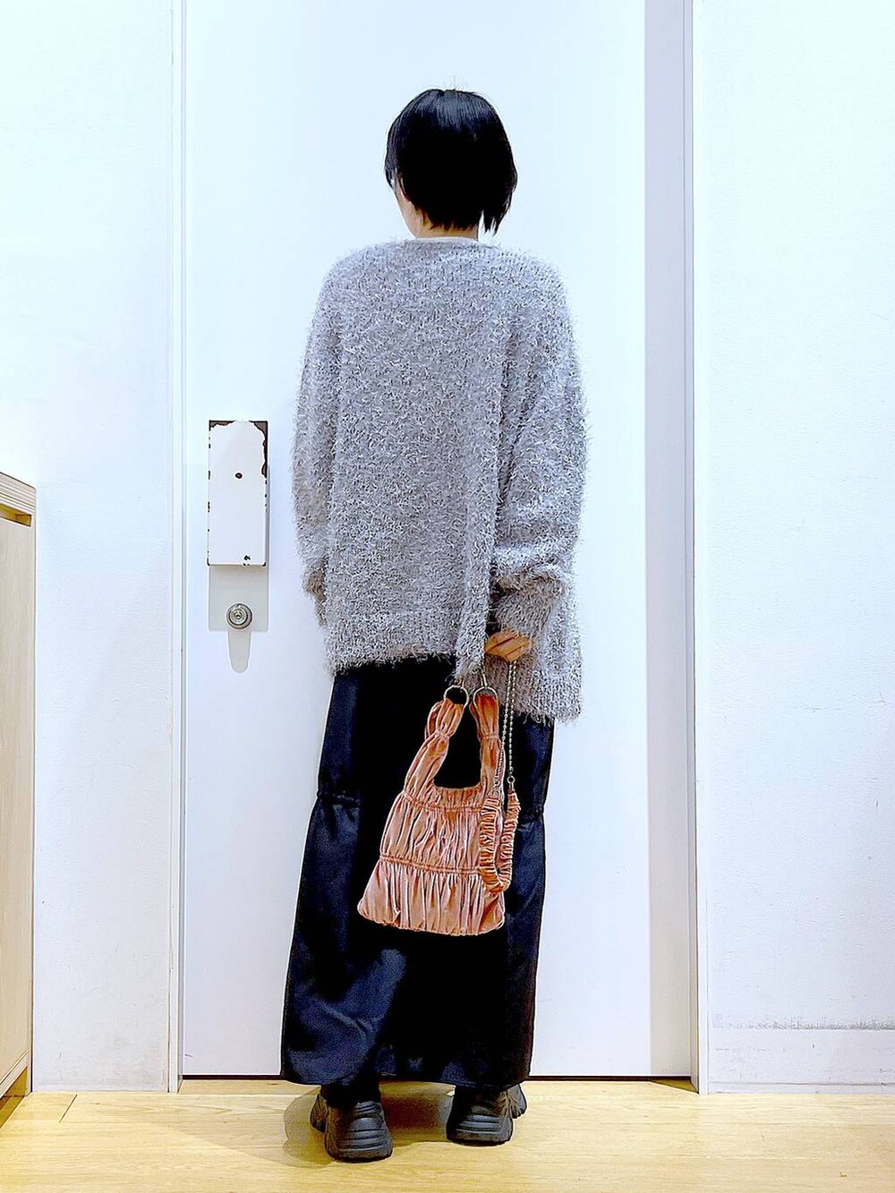 ホワイト系のニット/セーター、ピンク系のショルダーバッグ、グレー系のカーディガン/ボレロを着用したレディースの冬コーディネートの5枚目の写真