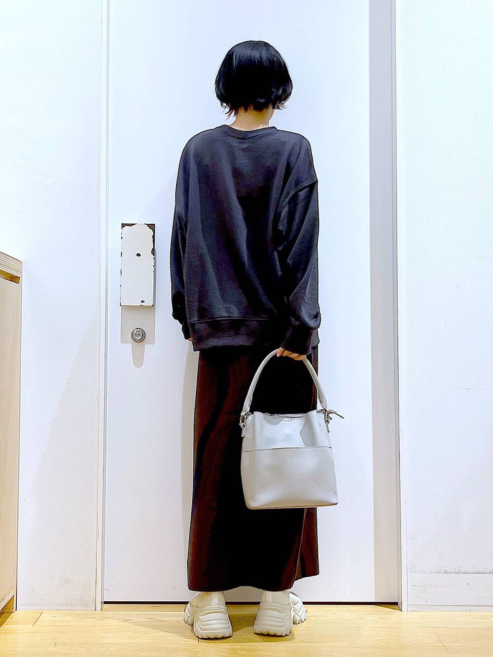 ブラウン系のスカート、グレー系のショルダーバッグ、ベージュ系のブーツを着用したレディースの冬コーディネートの5枚目の写真