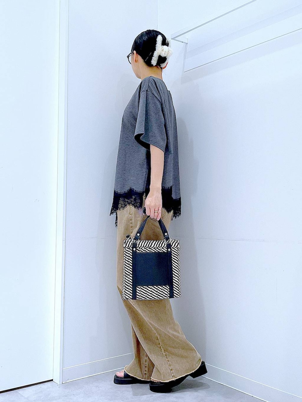 その他のショルダーバッグ、ブラック系のサンダル、ベージュ系のデニムパンツを着用したレディースの夏コーディネートの3枚目の写真