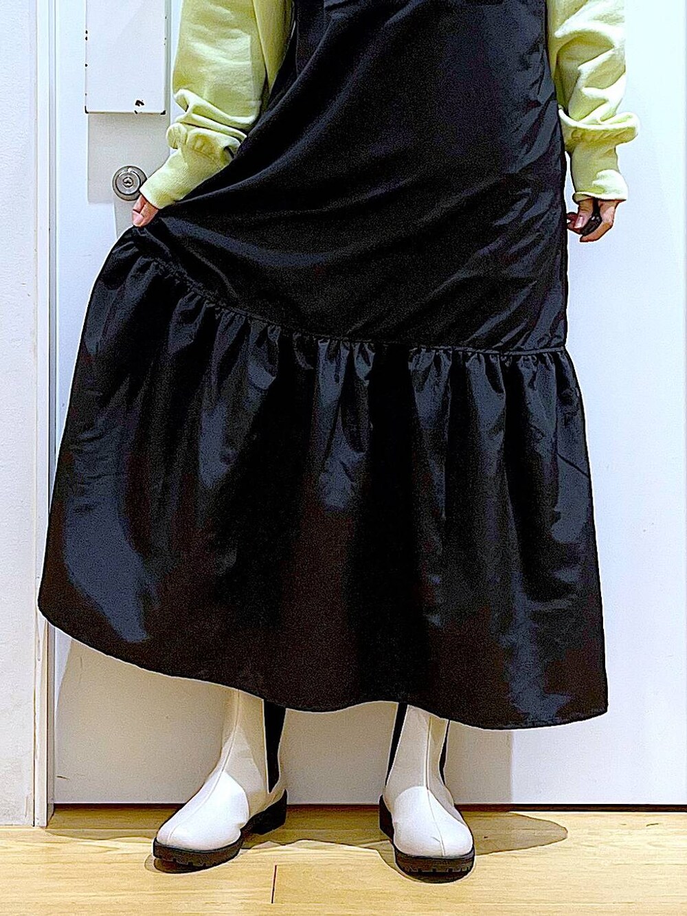 イエロー系のスウェット、ベージュ系のブーツ、その他のショルダーバッグを着用したレディースの冬コーディネートの8枚目の写真