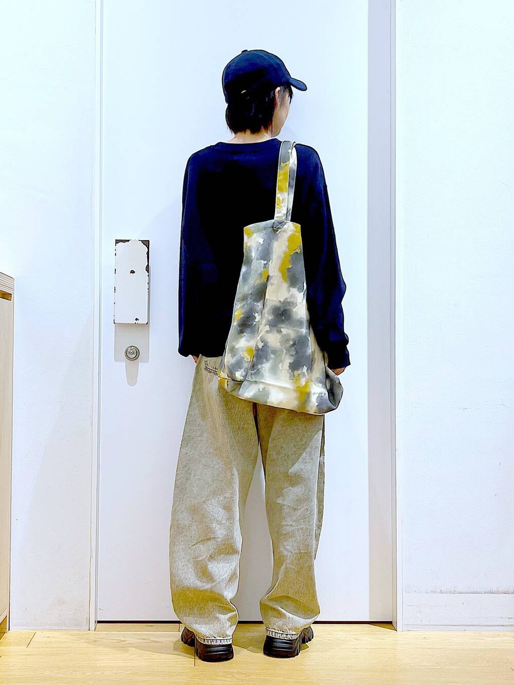 ブラック系のブーツ、ベージュ系のデニムパンツ、イエロー系のトートバッグを着用したレディースの冬コーディネートの5枚目の写真