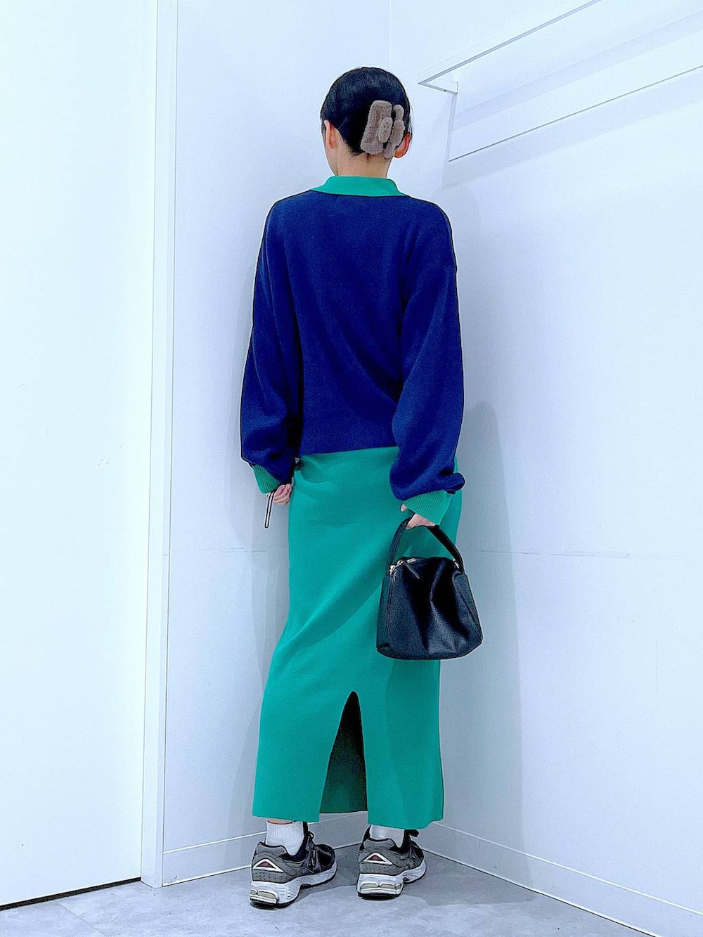 ブラック系のショルダーバッグ、ブルー系のカーディガン/ボレロ、グリーン系のスカートを着用したレディースの春コーディネートの5枚目の写真