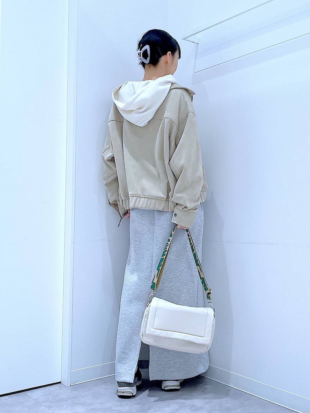 ホワイト系のショルダーバッグ、ベージュ系のニット/セーター、グレー系のスカートを着用したレディースの春コーディネートの5枚目の写真