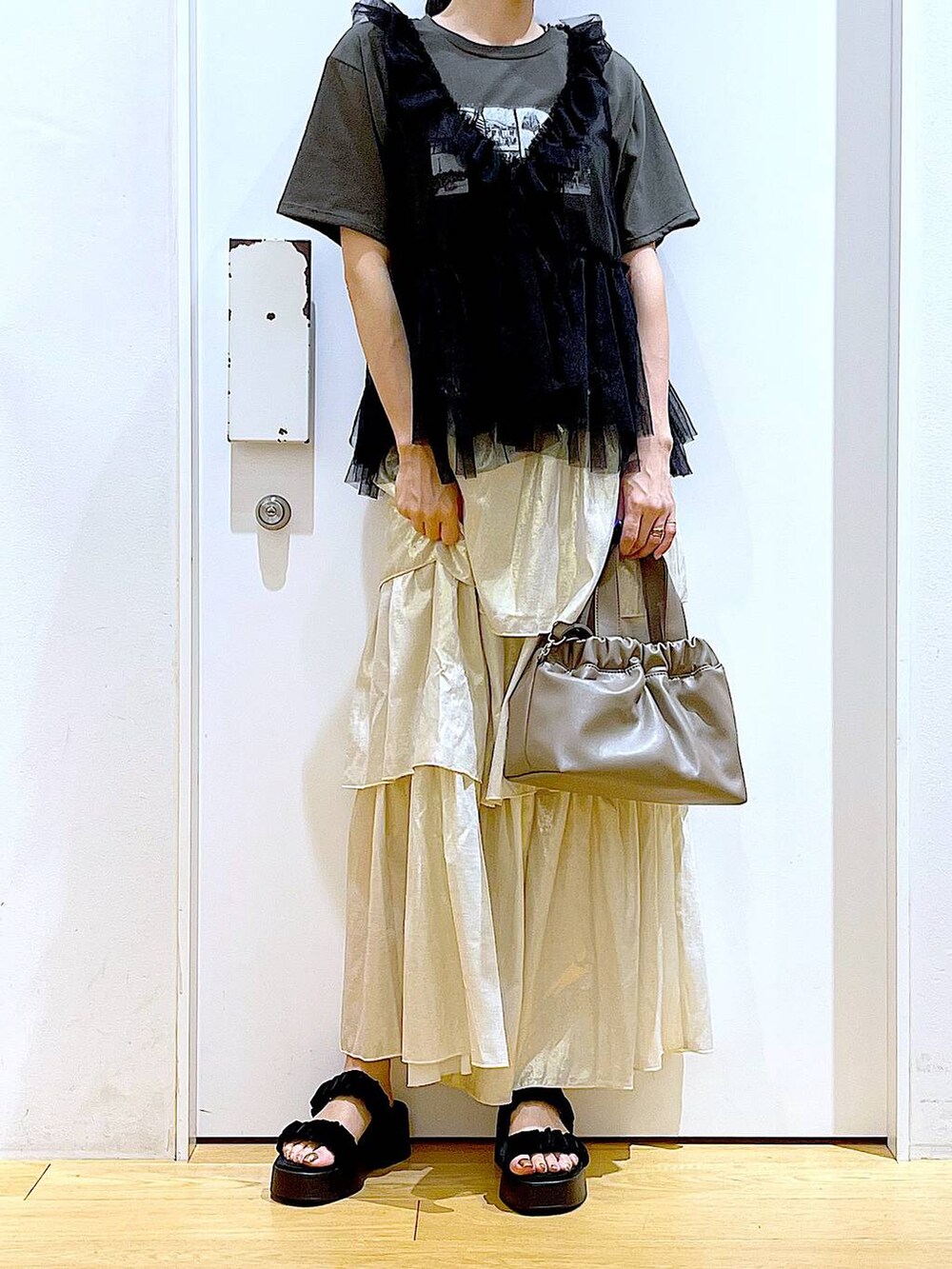 ブラック系のサンダル、ブラウン系のショルダーバッグ、グレー系のTシャツ/カットソーを着用したレディースの夏コーディネートの6枚目の写真
