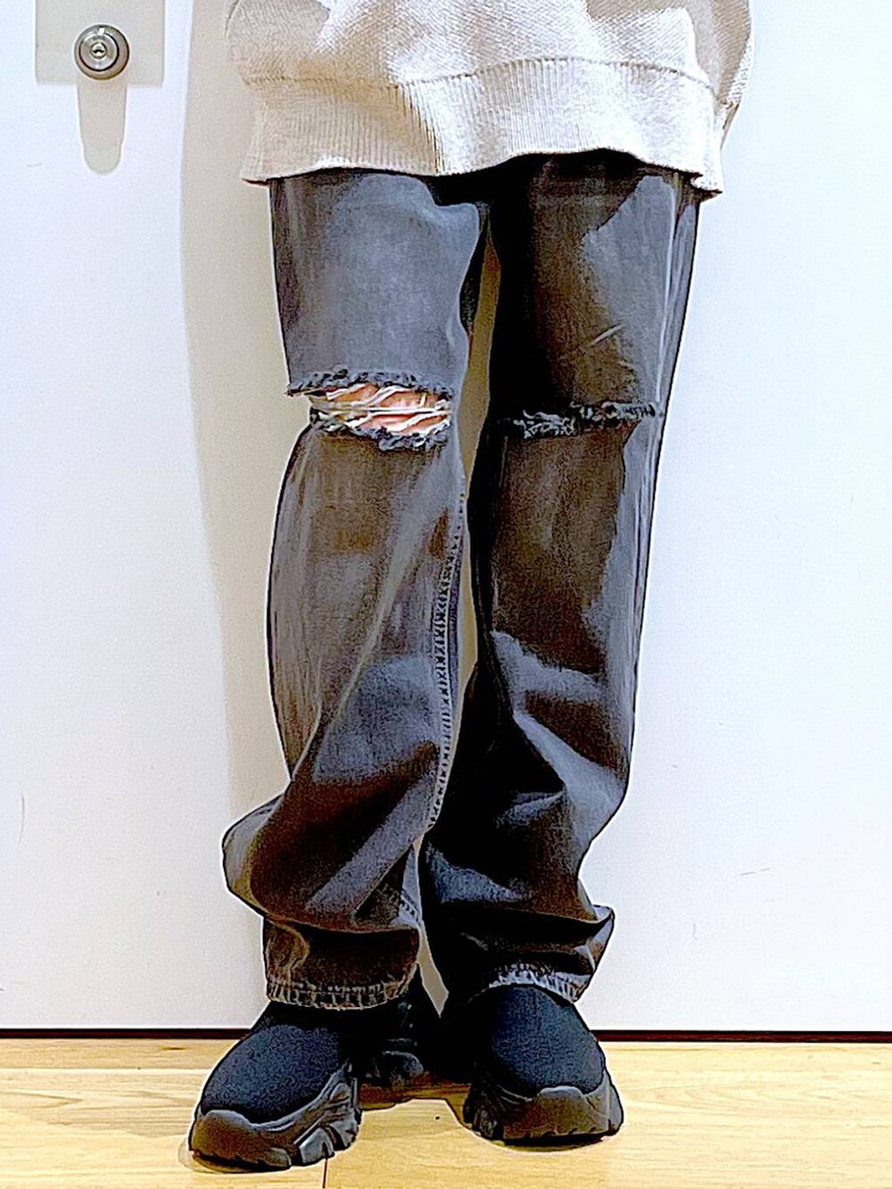 ブラック系のブーツ、ベージュ系のニット/セーター、ブルー系のデニムパンツを着用したレディースの冬コーディネートの8枚目の写真