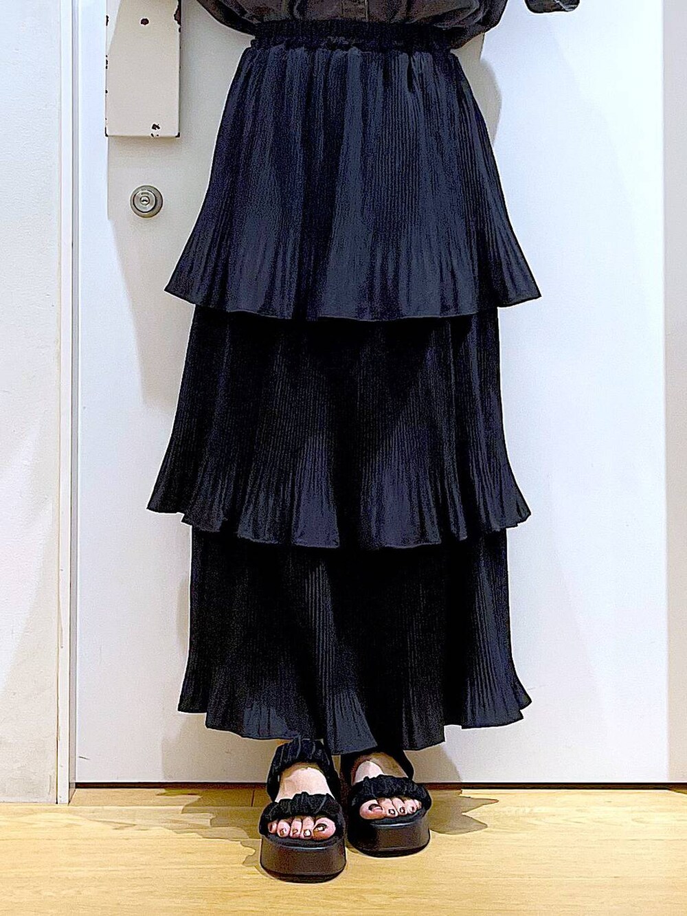 シルバー系のショルダーバッグ、ブラック系のスカート、ブラック系のサンダルを着用したレディースの夏コーディネートの8枚目の写真