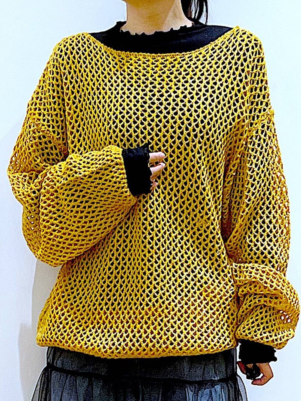 ブルー系のデニムパンツ、ブラック系のTシャツ/カットソー、オレンジ系のニット/セーターを着用したレディースの冬コーディネートの7枚目の写真