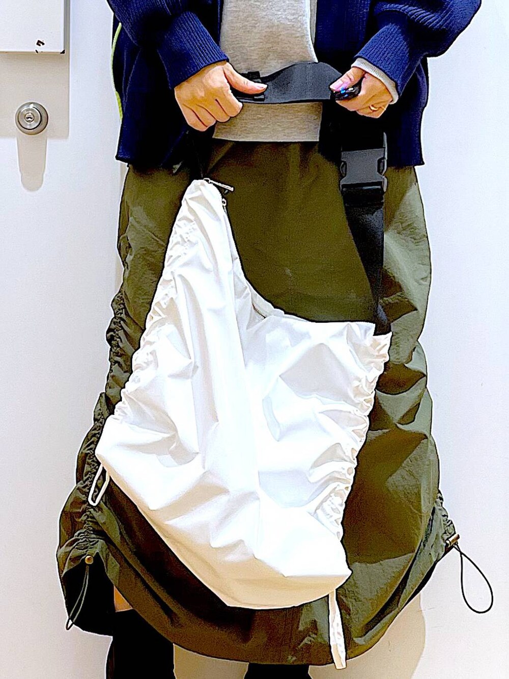 グレー系のスウェット、ブラック系のブーツ、グリーン系のスカートを着用したレディースの冬コーディネートの9枚目の写真