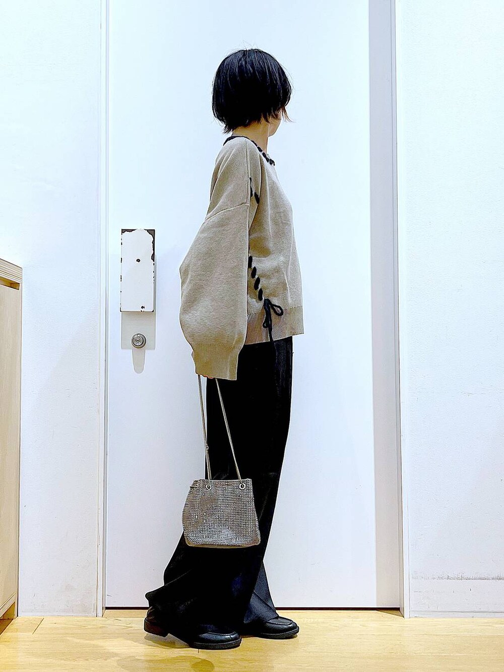 グレー系のショルダーバッグ、ブラック系のローファー、ブラウン系のニット/セーターを着用したレディースの冬コーディネートの4枚目の写真