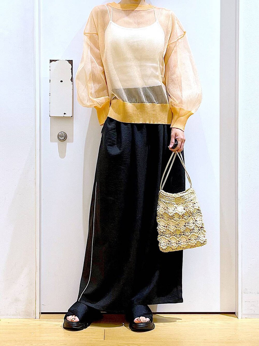 ブラック系のサンダル、オレンジ系のカーディガン/ボレロ、ベージュ系のショルダーバッグを着用したレディースの夏コーディネートの6枚目の写真