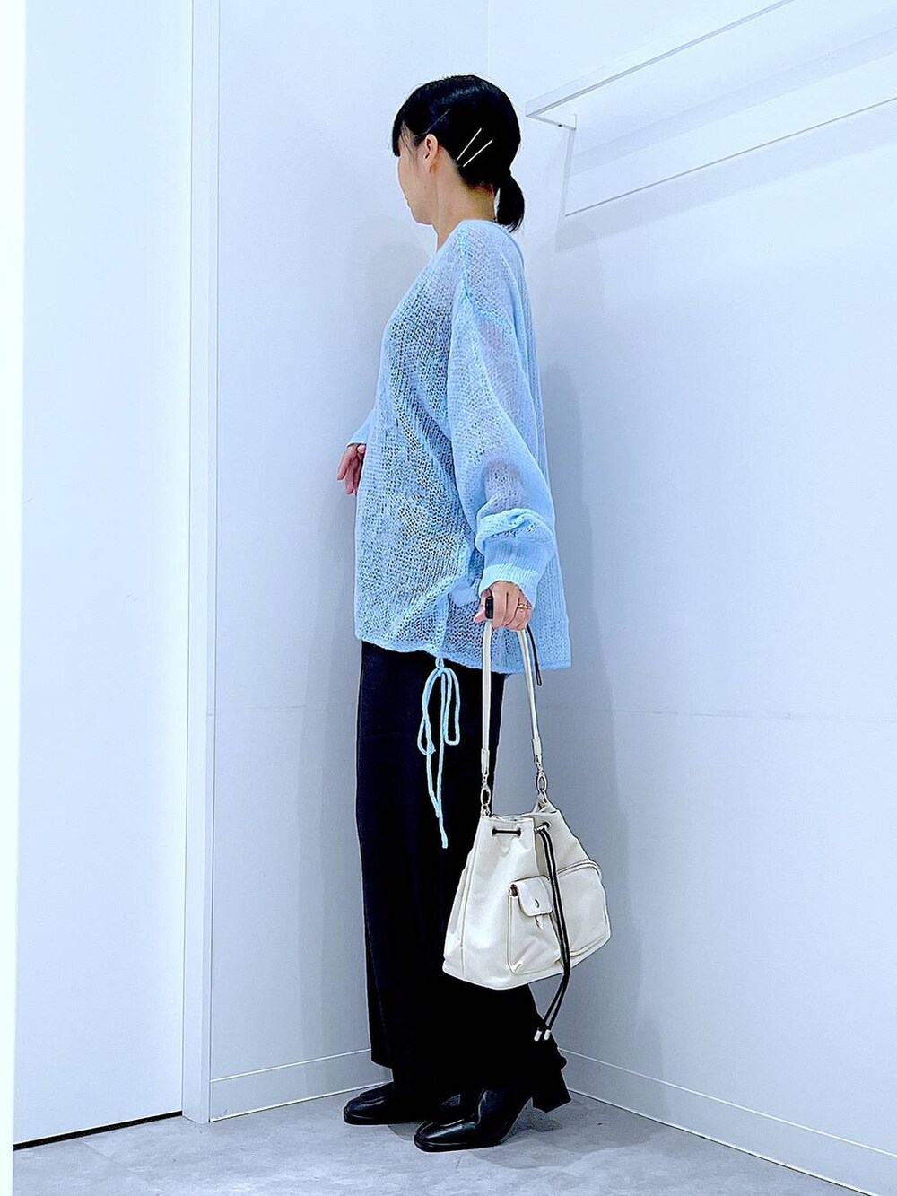 ブラック系のその他パンツ、ホワイト系のショルダーバッグ、ブラック系のブーツを着用したレディースの冬コーディネートの3枚目の写真