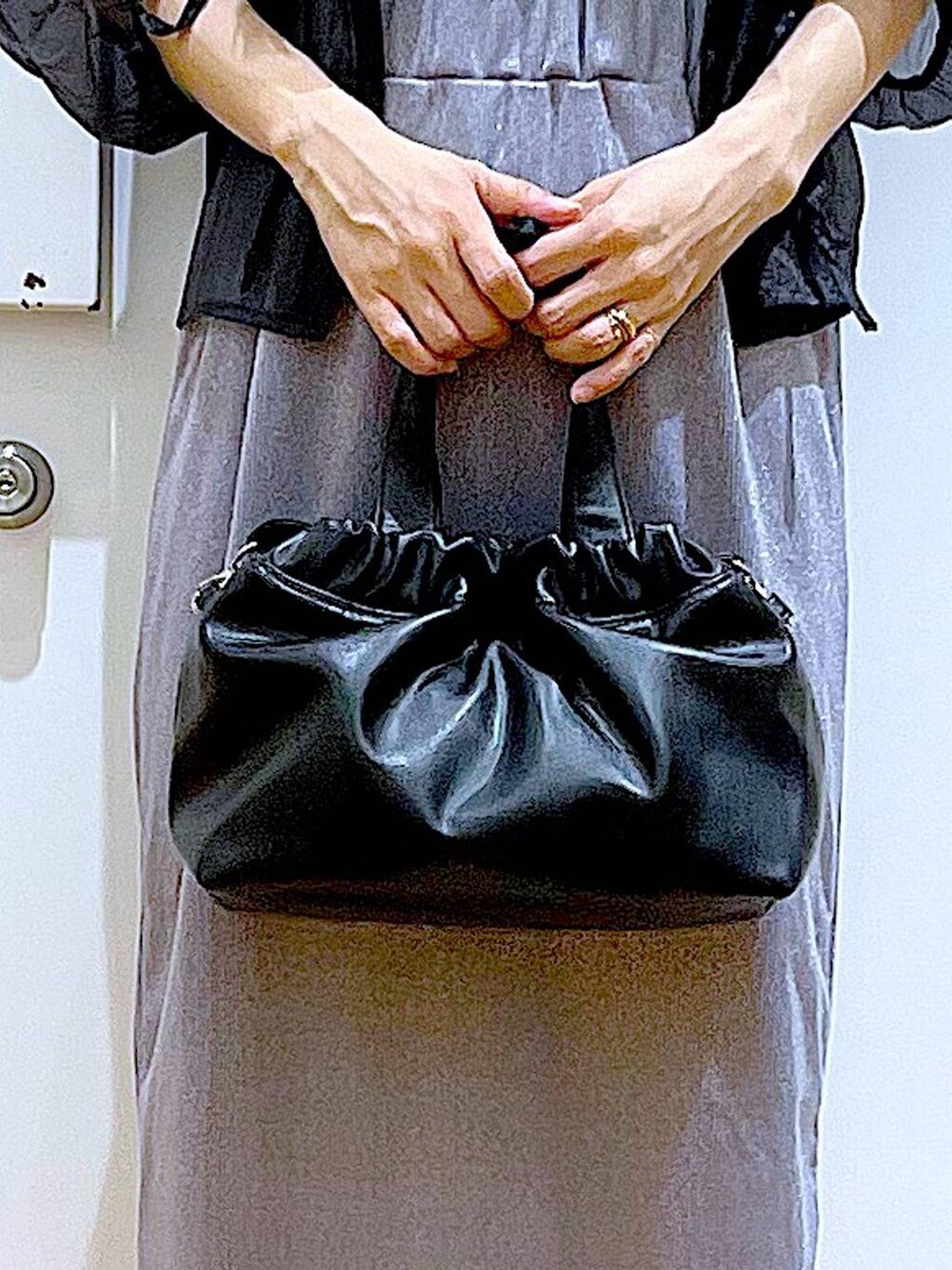 パープル系のスカート、ブラック系のサンダル、ブラック系のニット/セーターを着用したレディースの夏コーディネートの9枚目の写真