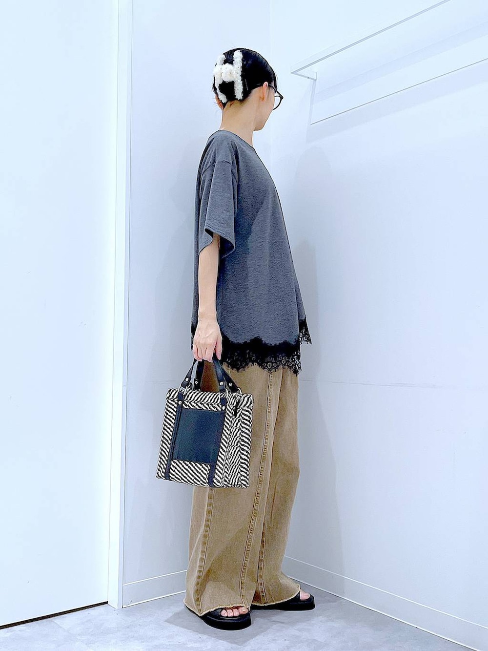 その他のショルダーバッグ、ブラック系のサンダル、ベージュ系のデニムパンツを着用したレディースの夏コーディネートの4枚目の写真