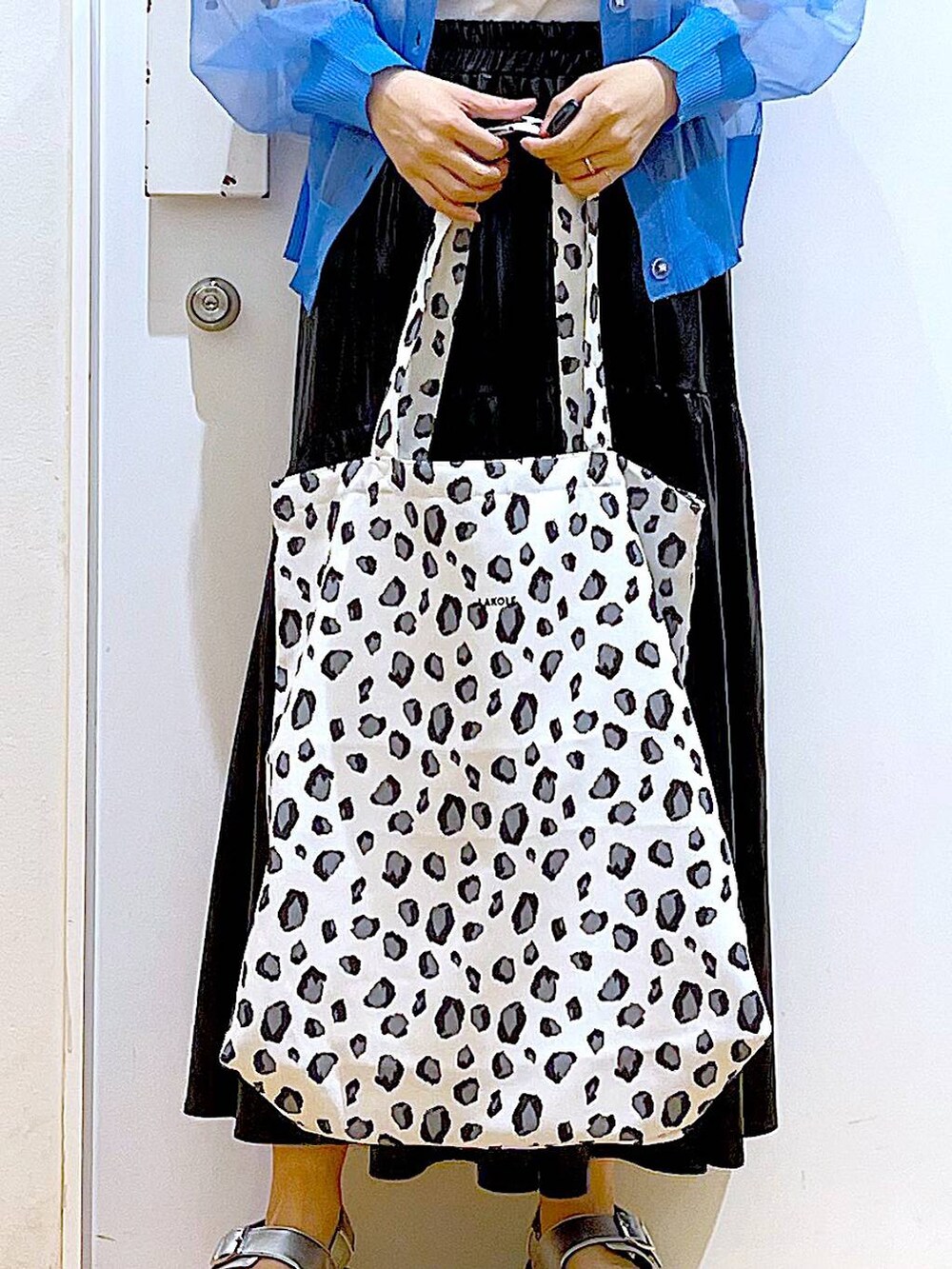 シルバー系のサンダル、ブルー系のカーディガン/ボレロ、ホワイト系のトートバッグを着用したレディースの夏コーディネートの9枚目の写真