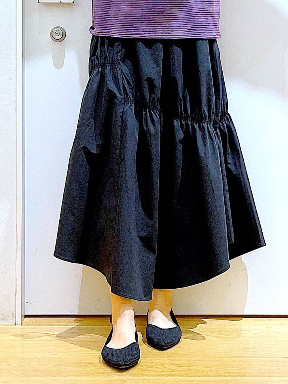 ブラック系のパンプス、ブラウン系のTシャツ/カットソー、ブラック系のスカートを着用したレディースの夏コーディネートの8枚目の写真