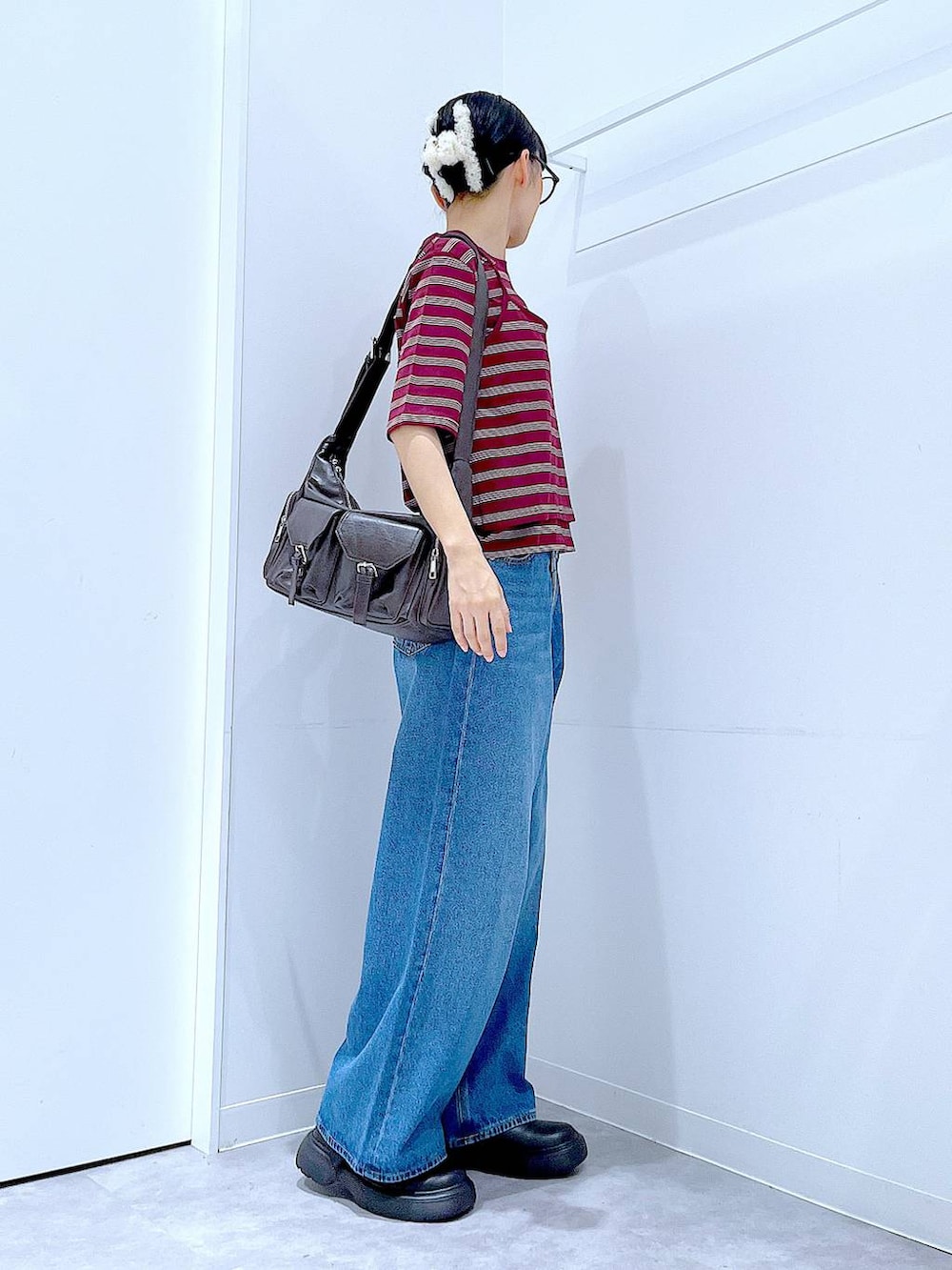 ブルー系のデニムパンツ、レッド系のTシャツ/カットソー、ブラック系のその他シューズを着用したレディースの秋コーディネートの4枚目の写真