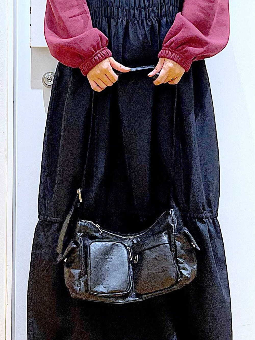 ブラック系のブーツ、ブラック系のショルダーバッグ、ブラック系のワンピースを着用したレディースの秋コーディネートの9枚目の写真