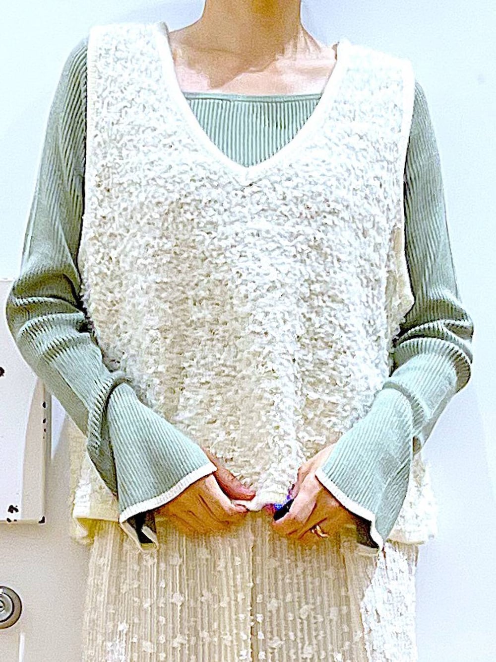 グリーン系のニット/セーター、グリーン系のショルダーバッグ、ベージュ系のベストを着用したレディースの秋コーディネートの7枚目の写真