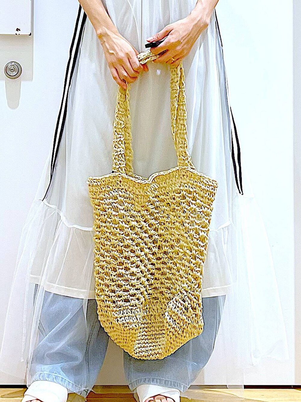 ホワイト系のサンダル、ブルー系のデニムパンツ、ホワイト系のトートバッグを着用したレディースの夏コーディネートの9枚目の写真