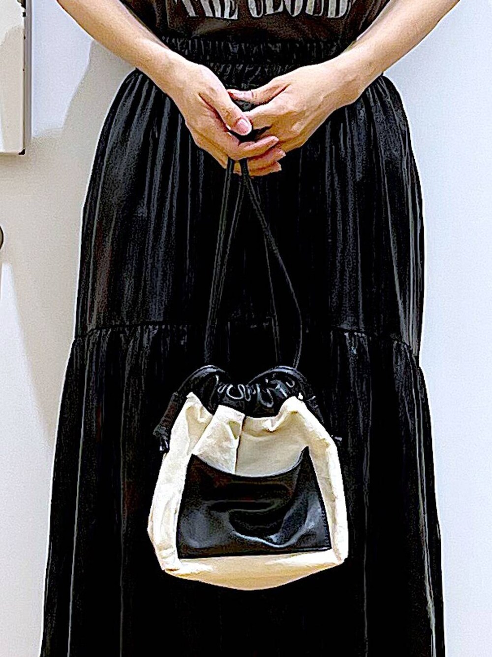 ホワイト系のショルダーバッグ、ブラック系のスリッポン、グレー系のTシャツ/カットソーを着用したレディースの夏コーディネートの9枚目の写真