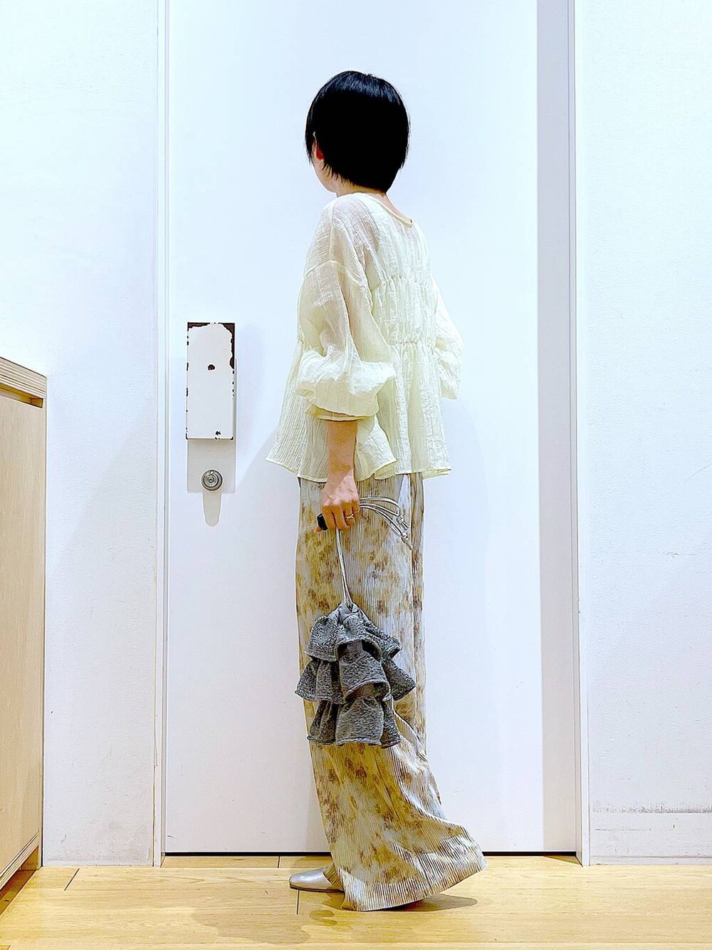 シルバー系のショルダーバッグ、シルバー系のパンプス、ベージュ系のシャツ/ブラウスを着用したレディースの夏コーディネートの3枚目の写真