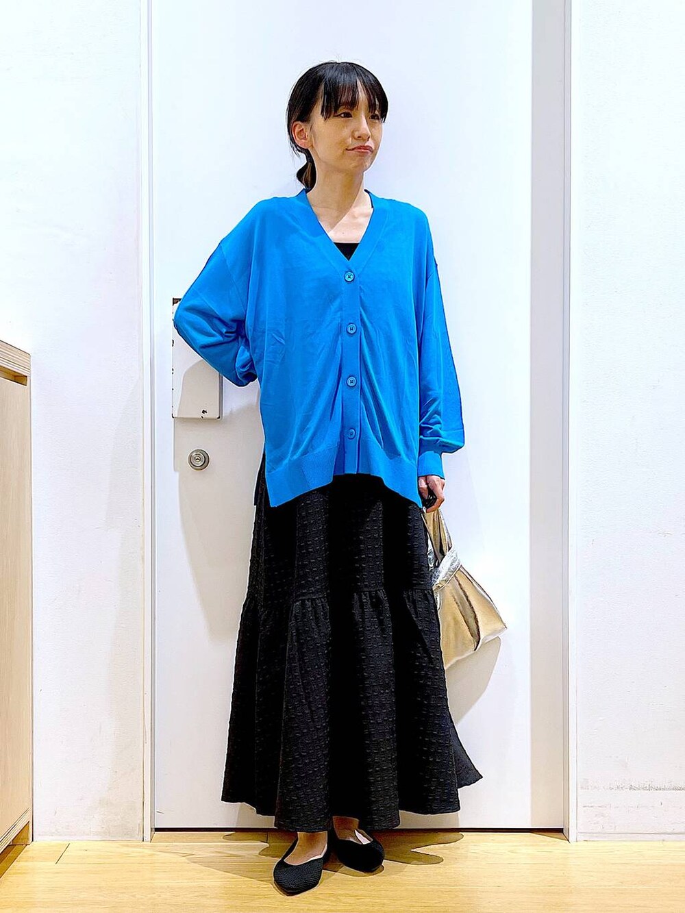 シルバー系のショルダーバッグ、ブラック系のワンピース、ブラック系のパンプスを着用したレディースの春コーディネートの2枚目の写真