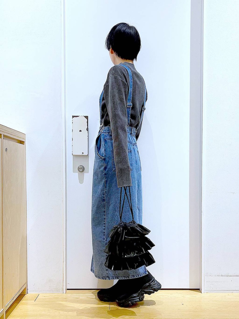 ブラック系のブーツ、ブラック系のショルダーバッグ、ブラック系のニット/セーターを着用したレディースの春コーディネートの3枚目の写真