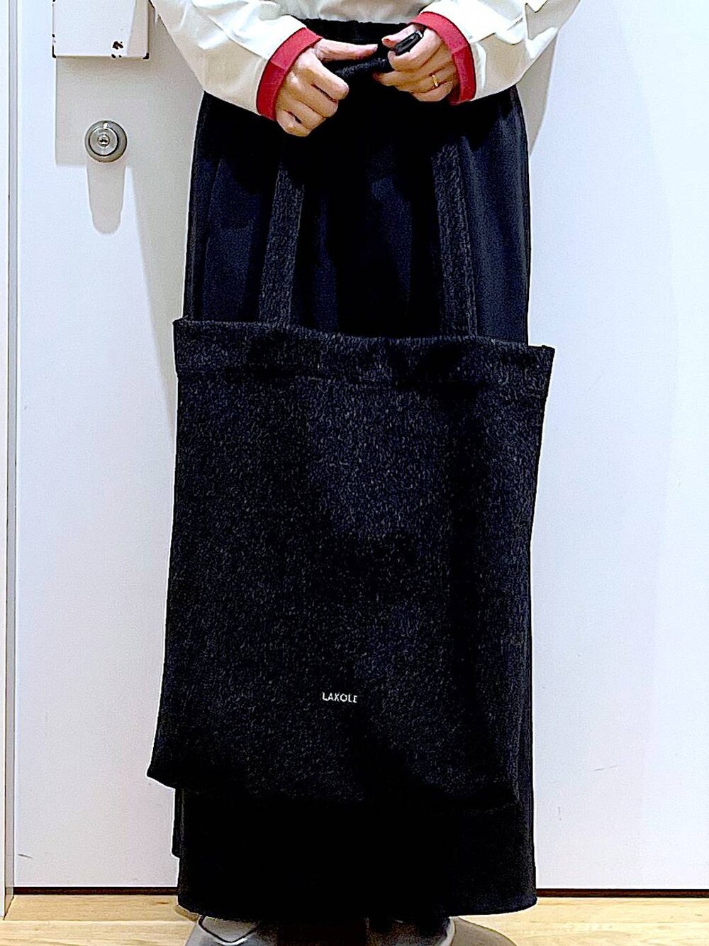 ブラック系のトートバッグ、シルバー系のパンプス、ブラック系のスカートを着用したレディースの春コーディネートの9枚目の写真